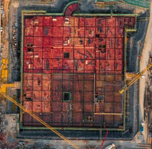 Aerial view of a construction site featuring a large amount of red bricks stacked atop one another
